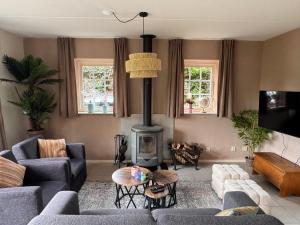 a living room with a couch and a fireplace at Vakantiewoning Uutbloazen in Lievelde