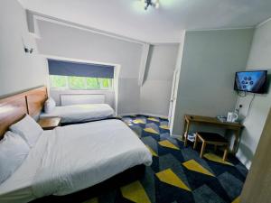 a hotel room with two beds and a television at Dream Hotel in Manchester