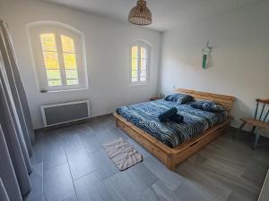 a bedroom with a bed and two windows at Auberge du Bourguet in Brenon +9 photos