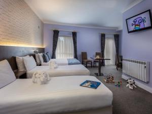 a hotel room with two beds with stuffed animals on them at Treacy's Hotel & Slaney Suites Wexford in Enniscorthy +22 photos