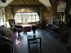 ein Wohnzimmer mit einem Sofa und einem TV in der Unterkunft Clos Du Ry De Snaye in Beauraing