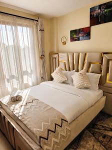 a large bed in a room with a window at Savanna Living in Nakuru +21 photos