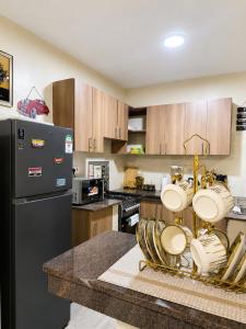 a kitchen with wooden cabinets and a black refrigerator at Savanna Living in Nakuru