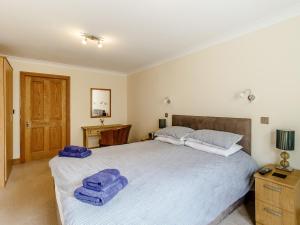 a bedroom with a large bed with blue towels on it at Orchard Sands in Beadnell