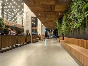 a restaurant lobby with a bar and plants at ibis Styles Maceió Pajuçara in Maceió +134 photos