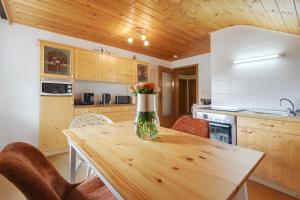 a kitchen with a table with a vase of flowers on it at Bayernseele - Bayerwald in Spiegelau