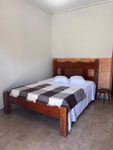 a bedroom with a bed with a black and white blanket at Pousada Cachoeira do Campo in Aquidauana