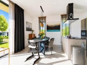 a kitchen and dining room with a table and chairs at Harderwold Villa - 412 in Zeewolde +29 photos