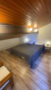 a large bed in a room with a wooden ceiling at Chalet Rec Fred in Matemale
