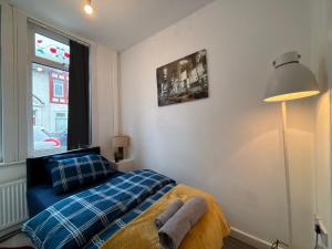 ein Schlafzimmer mit einem blauen Bett und einem Fenster in der Unterkunft Middlesbrough Lodge in Middlesbrough