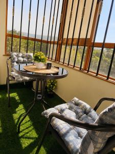 a table and chairs in a room with windows at Savanna Living in Nakuru