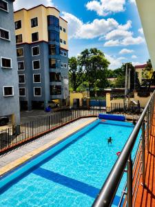a person swimming in a swimming pool on top of a building at Savanna Living in Nakuru