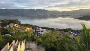 a view of a large body of water with buildings at Mirante Piratininga - Casa 2 quartos - Vista Panorâmica Lagoa e Praia in Niterói