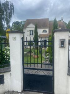 a gate to a house with a yard at Le wagon roulotte in Thorigny-sur-Marne