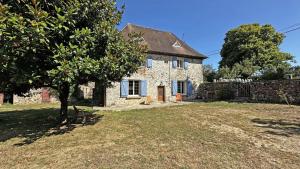an old stone house with a tree in the yard at Chez mémé marie in Rilhac-Lastours