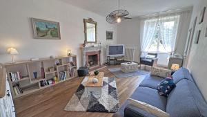 a living room with a blue couch and a fireplace at Chez mémé marie in Rilhac-Lastours
