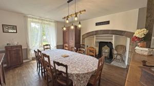 a dining room with a table and a fireplace at Chez mémé marie in Rilhac-Lastours