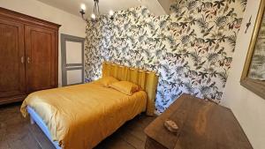 a bedroom with a bed and a floral wallpaper at Chez mémé marie in Rilhac-Lastours