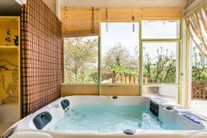 a large bath tub in a room with a window at Maison d'Hôtes L'Escale Du Loup Blanc in Maringes