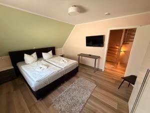 a bedroom with a bed and a table and a television at Villa Fleesenstrand in Göhren-Lebbin +31 photos