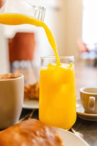 a glass of orange juice on a table at School Lane Hotel in Liverpool ONE in Liverpool