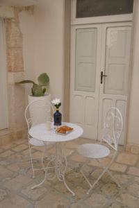 a table and two chairs and a table and a door at Borgo Sant' Angelo Exclusive House in Conversano