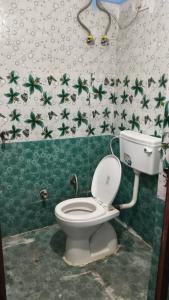 a bathroom with a toilet and a green and white wall at Hotel Diamond in Gwalior