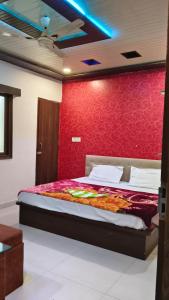a bedroom with a bed with a red wall at Hotel Diamond in Gwalior