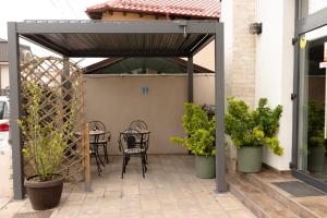 a pergola with a table and chairs on a patio at No. 55 in Buzău