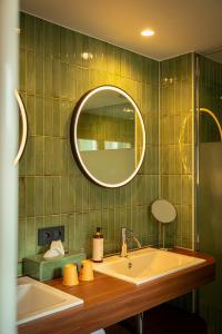 a bathroom with a sink and a mirror at Hotel Amfora in Poperinge +36 photos