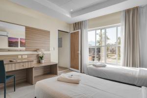 a hotel room with two beds and a desk at 800 Mountains view in Fujairah