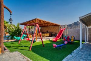 a playground with a swing set on the grass at 800 Mountains view in Fujairah
