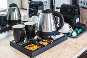 a coffee maker on a kitchen counter with two cups at 800 Mountains view in Fujairah