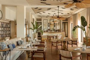 a restaurant with tables and chairs and a bar at Allium Bodrum Resort & Spa in Yalıkavak