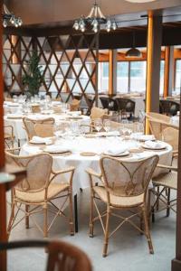 a dining room with white tables and chairs at Hotel Faisanera Golf in Palazuelos de Eresma