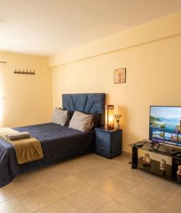 a bedroom with a bed and a flat screen tv at Small functional and impeccable loft facing the sea in Douar el Arbi Ben Ahmed