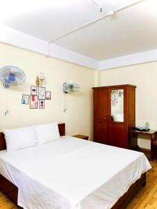 a bedroom with a white bed and a cabinet at Oriio Hotel in Cat Ba +9 photos