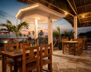a restaurant with a table and chairs on a patio at Smile Boutique Beach hotel in Nungwi