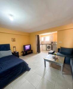 a bedroom with a bed and a couch and a table at Small functional and impeccable loft facing the sea in Douar el Arbi Ben Ahmed