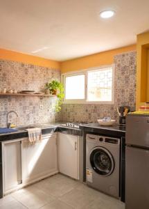 a kitchen with a sink and a washing machine at Small functional and impeccable loft facing the sea in Douar el Arbi Ben Ahmed