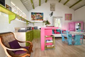 a kitchen with pink and green cabinets and a table at Villa Lorizon in Rodrigues Island