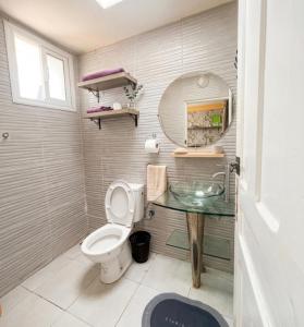 a bathroom with a toilet and a sink and a mirror at Small functional and impeccable loft facing the sea in Douar el Arbi Ben Ahmed +9 photos