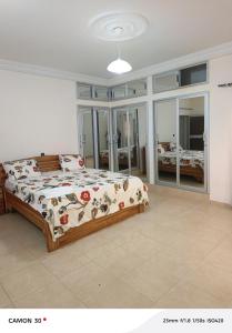 a bedroom with a bed with a floral comforter at Baie des Anges in Lomé