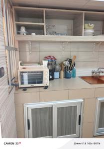 a kitchen with a microwave and a toaster oven at Baie des Anges in Lomé +28 photos