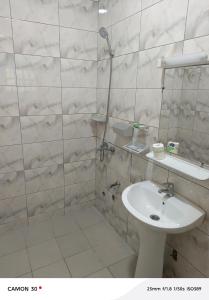 a bathroom with a shower and a toilet and a sink at Baie des Anges in Lomé