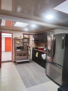 a kitchen with a stainless steel refrigerator at Hospedaje Entre Líneas in Salento