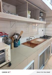 a kitchen with a sink and a stove at Baie des Anges in Lomé