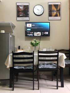 a table with two chairs and a tv on the wall at Accommodating Place in Manila