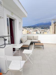a balcony with a couch and a table and chairs at Heavenly joy in Patra
