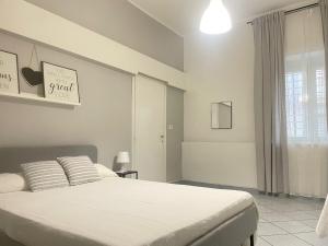 a bedroom with a large white bed and a window at Casa vacanze Da Fra in Cariati